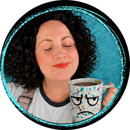 M— Dash with her eyes closed and a small smile, holding a speckled mug with a grumpy face.